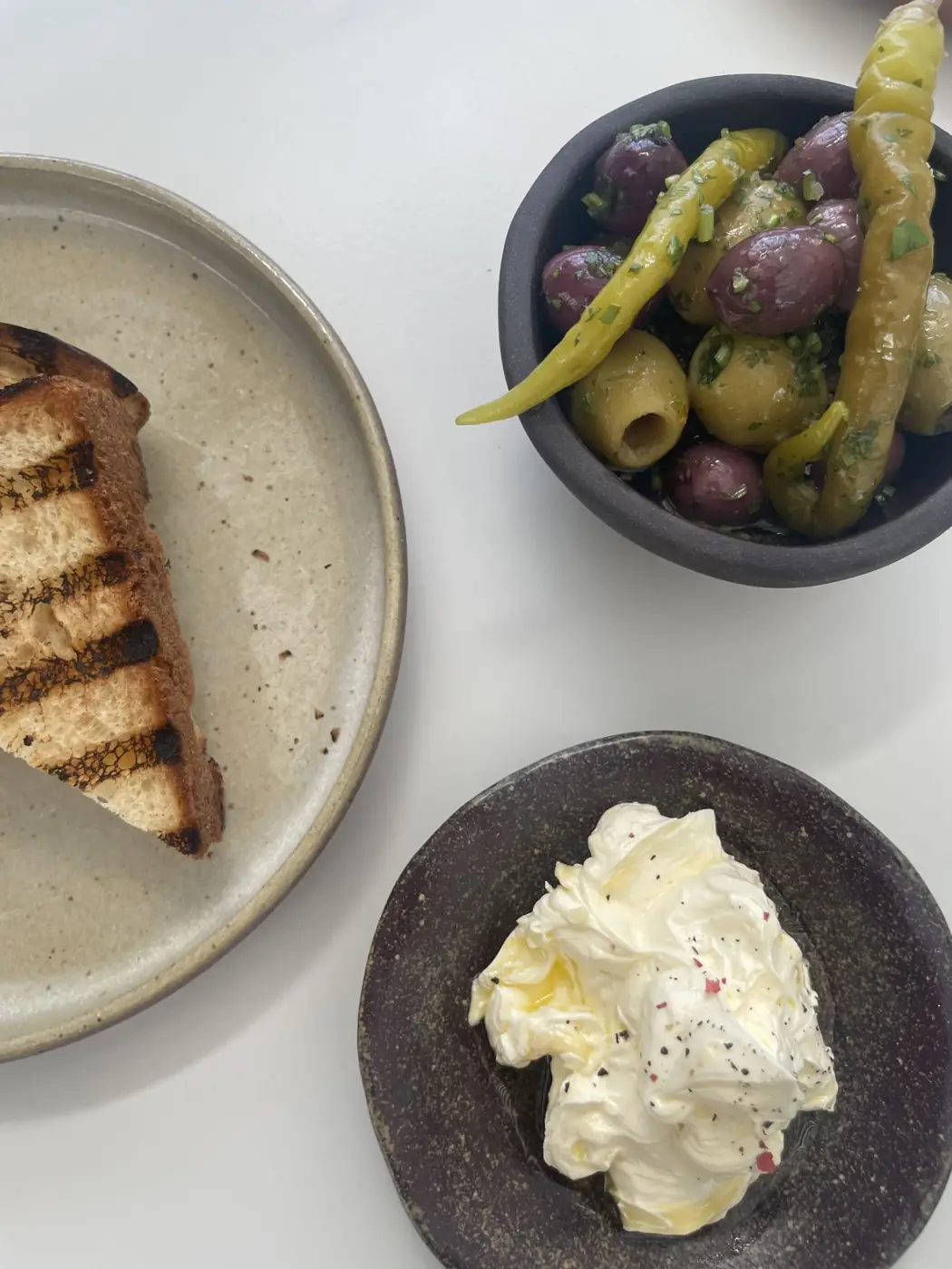 Olives, chillies, charred bread and whipped butter at Atrás