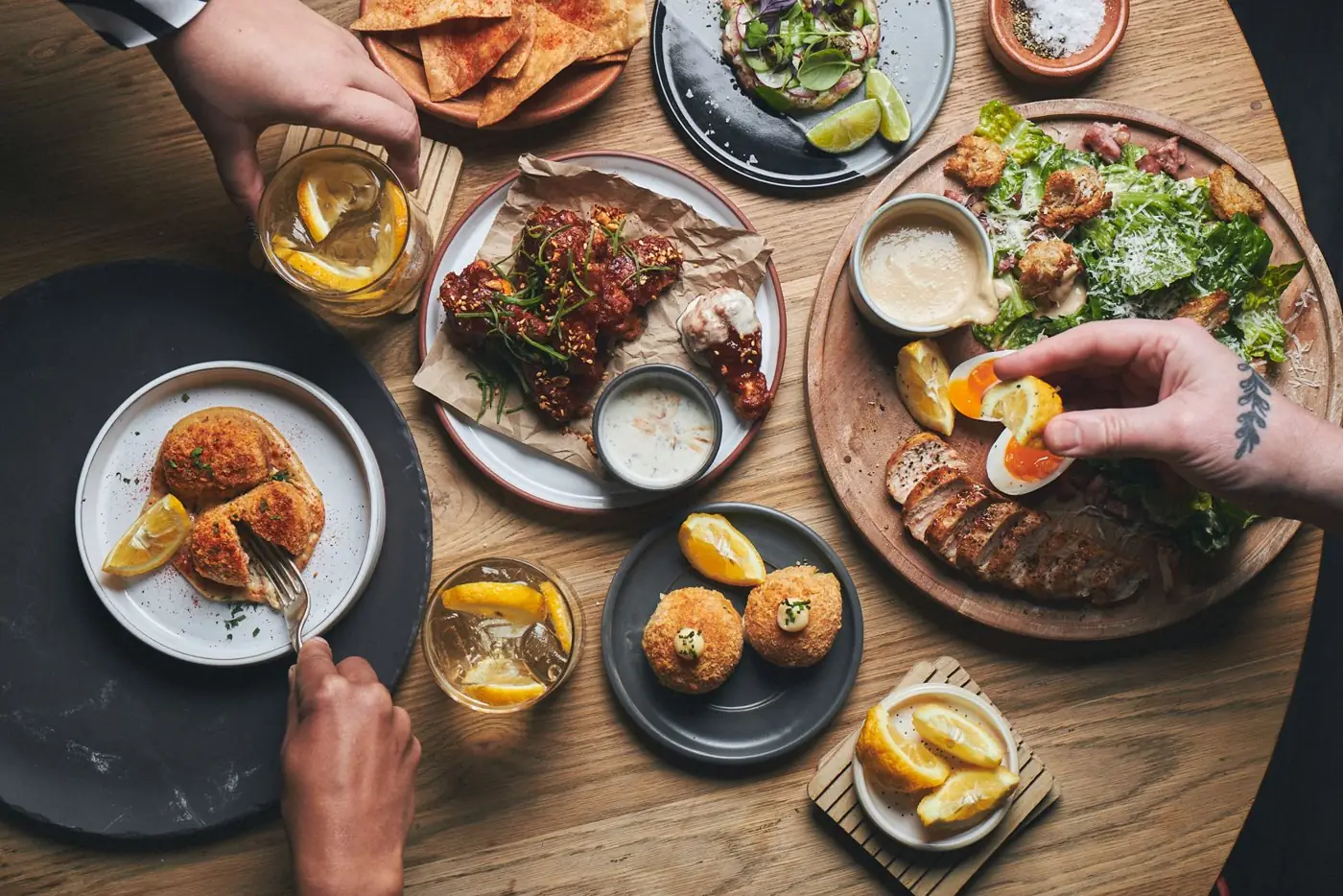 Sharing plates on a wooden table at Artistry, BlackBrick Sandton 2