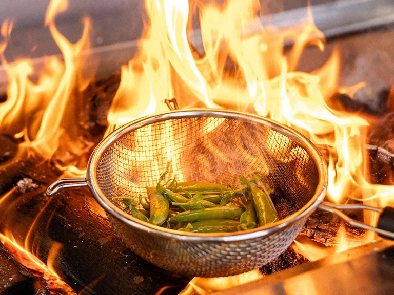 Food cooking over an open flame at BlackBrick Gardens